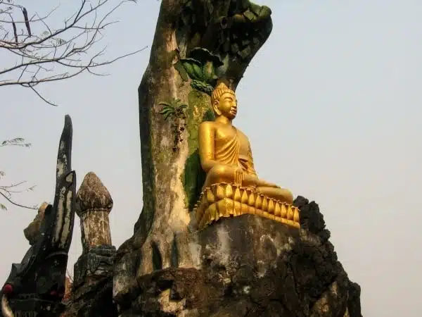 Golden Buddha statue on top of rock