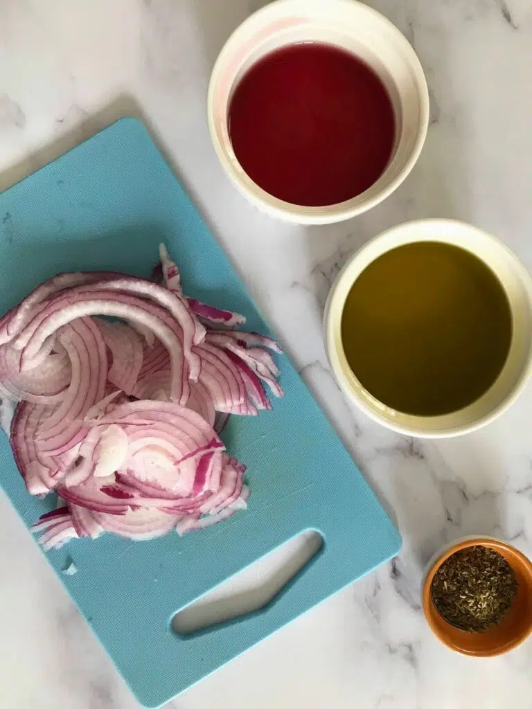 sliced red onions, red wine vinegar, olive oil, and oregano in separate containers.