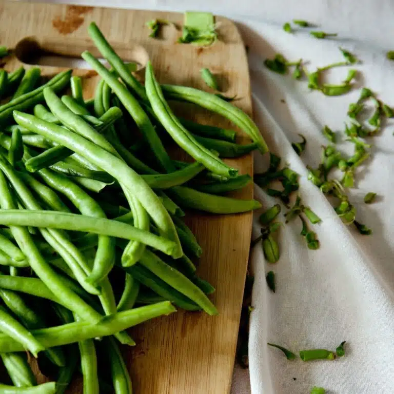 green beans trimmed on a cutting board.