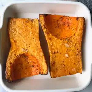 Roasted maple butternut squash in a white baking dish.